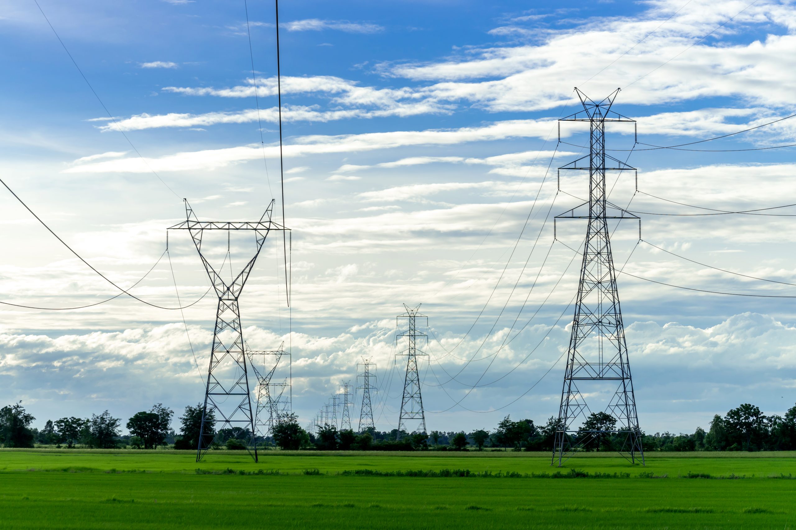 No blog com tema como comprar energia elétrica, a imagem mostra torres de transmissão e linhas de alta tensão utilizadas para transportar a energia elétrica.