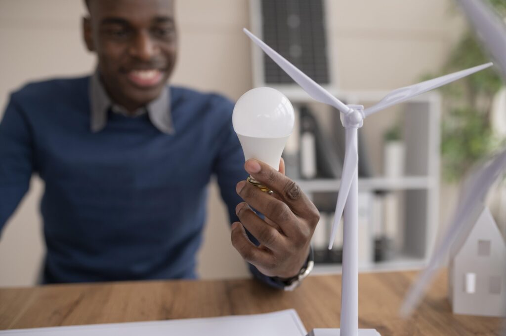 Homem olhando para uma lampada e tendo ideias de como conseguir desconto na conta de luz.