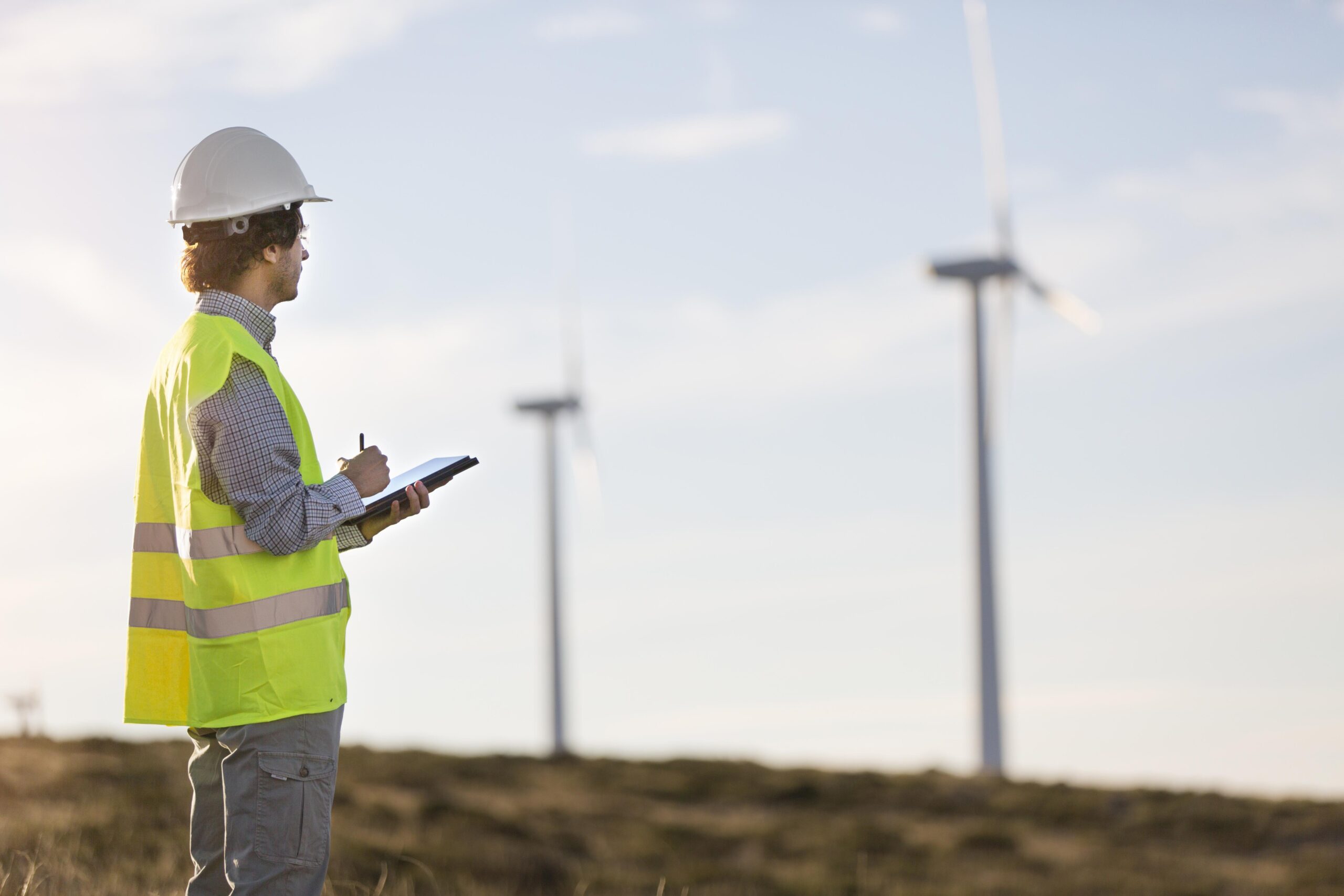 Mulher em um campo de energia eólica, mostrando o futuro da energia renovável.