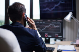 Visão traseira de um homem tendo uma ligação sobre gestão do book de energia com o CEO da empresa.